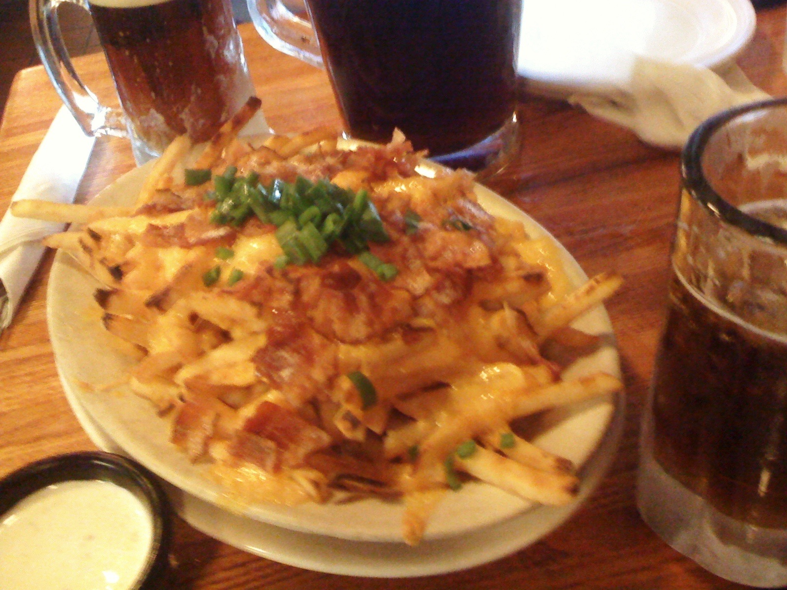 a plate with fries and some beer on the table