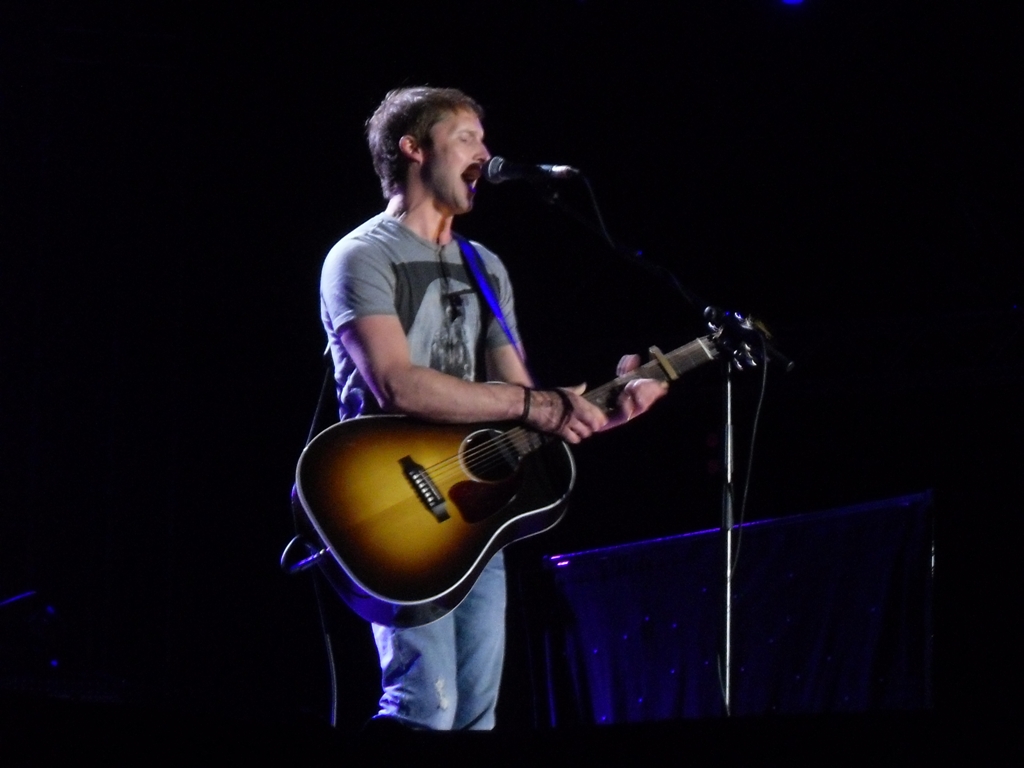 a man with his mouth open and a guitar in front of him