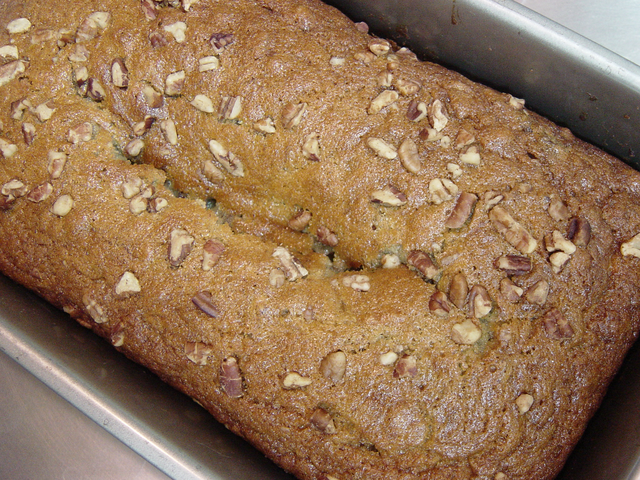 a loaf of bread covered in nuts in a pan