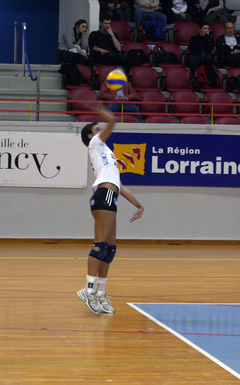 a woman playing volley ball in front of an audience