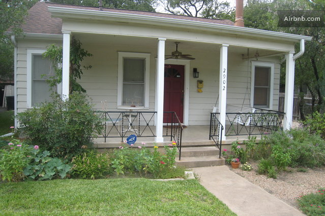 a small house is in the front yard of a house