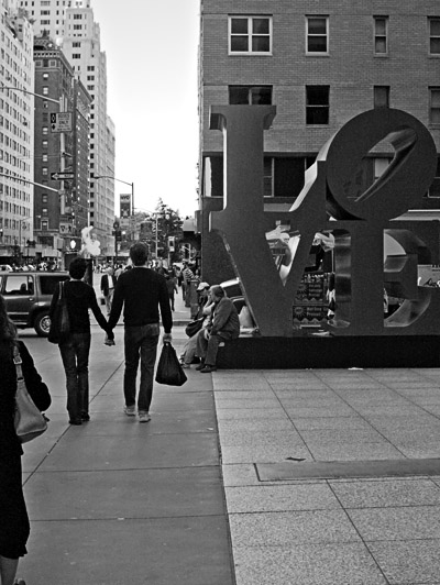 a black and white image of people on the sidewalk