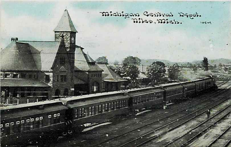 an old train station has a church and two trains on the tracks