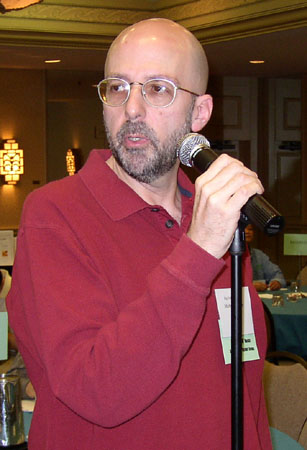 a man standing next to a microphone with a sign on it