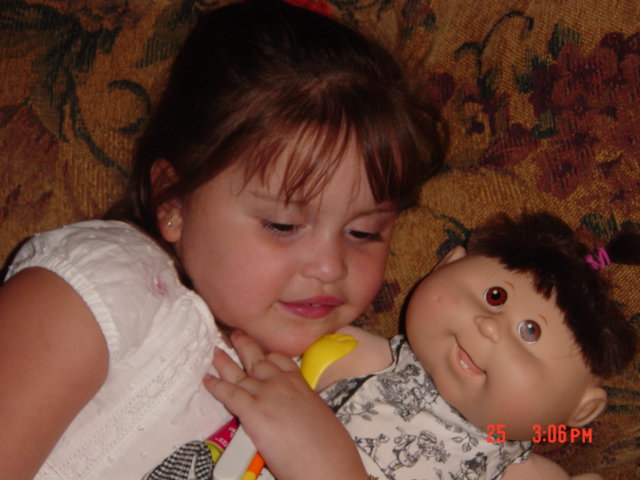 a small child with a doll in the lap of her