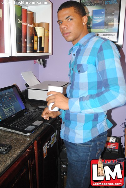 man in blue shirt standing next to computer desk