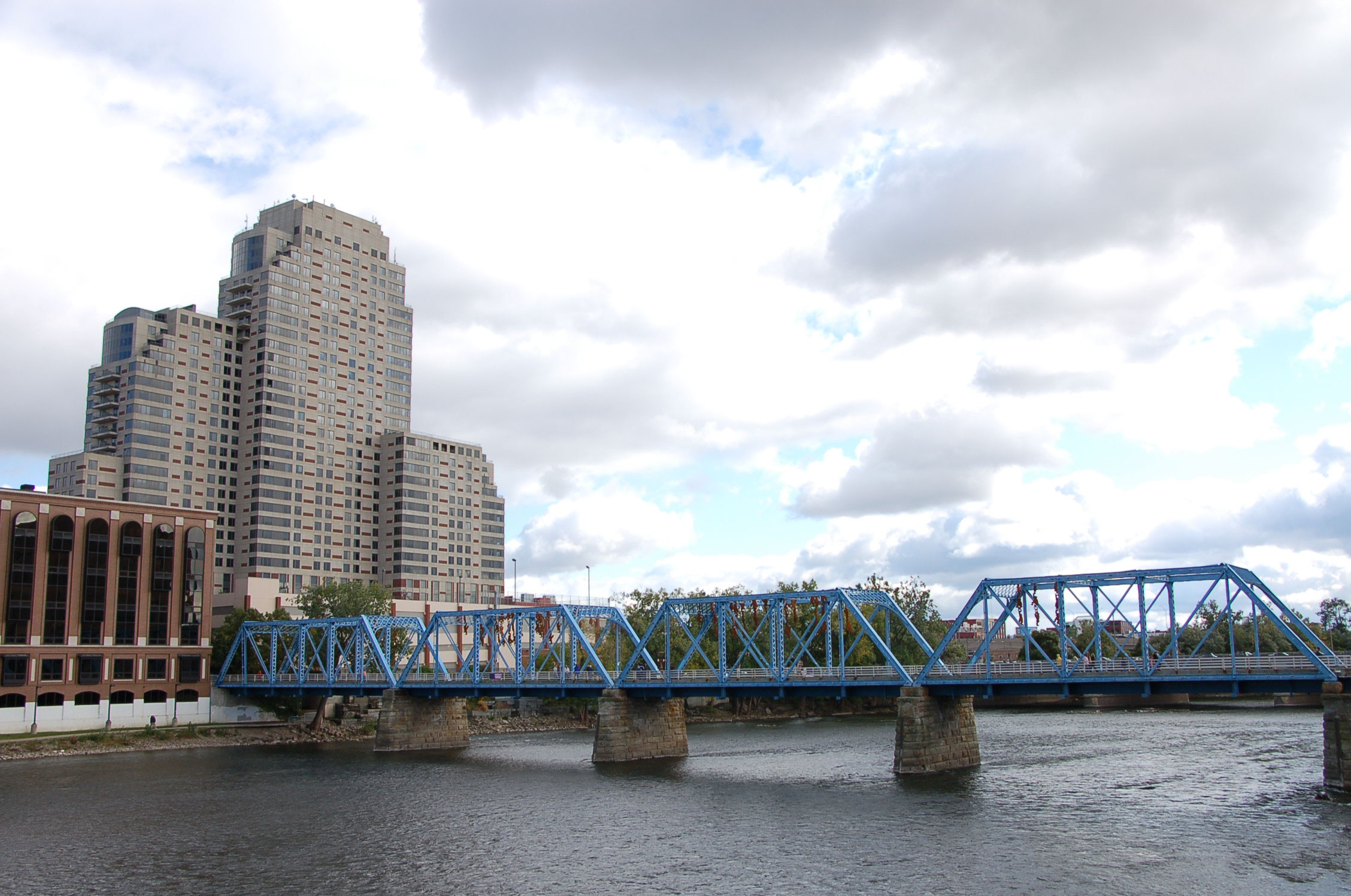 people are on a bridge over water near tall buildings