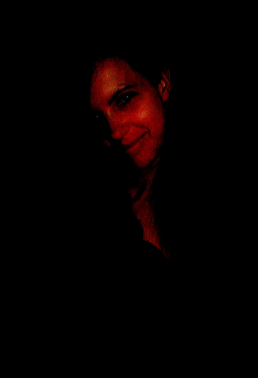 a black background with a portrait of a woman smiling in the dark
