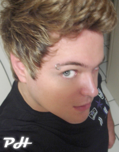 a young man with an eye piercing looks into the camera