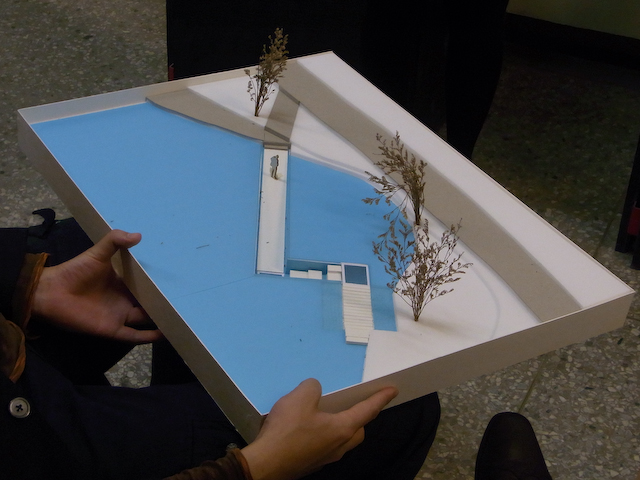 a person is holding a model house with plants