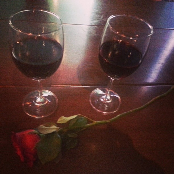 the two glasses have red wine next to one another