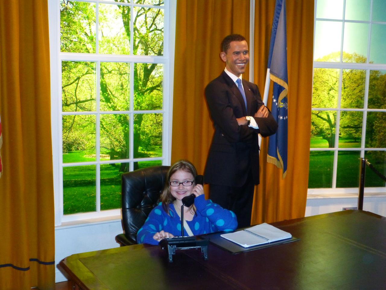 obama smiling with two young children in a large office