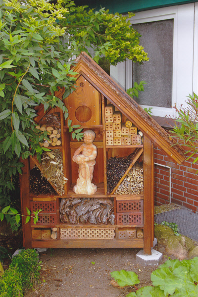 a small wooden doll house in front of a window