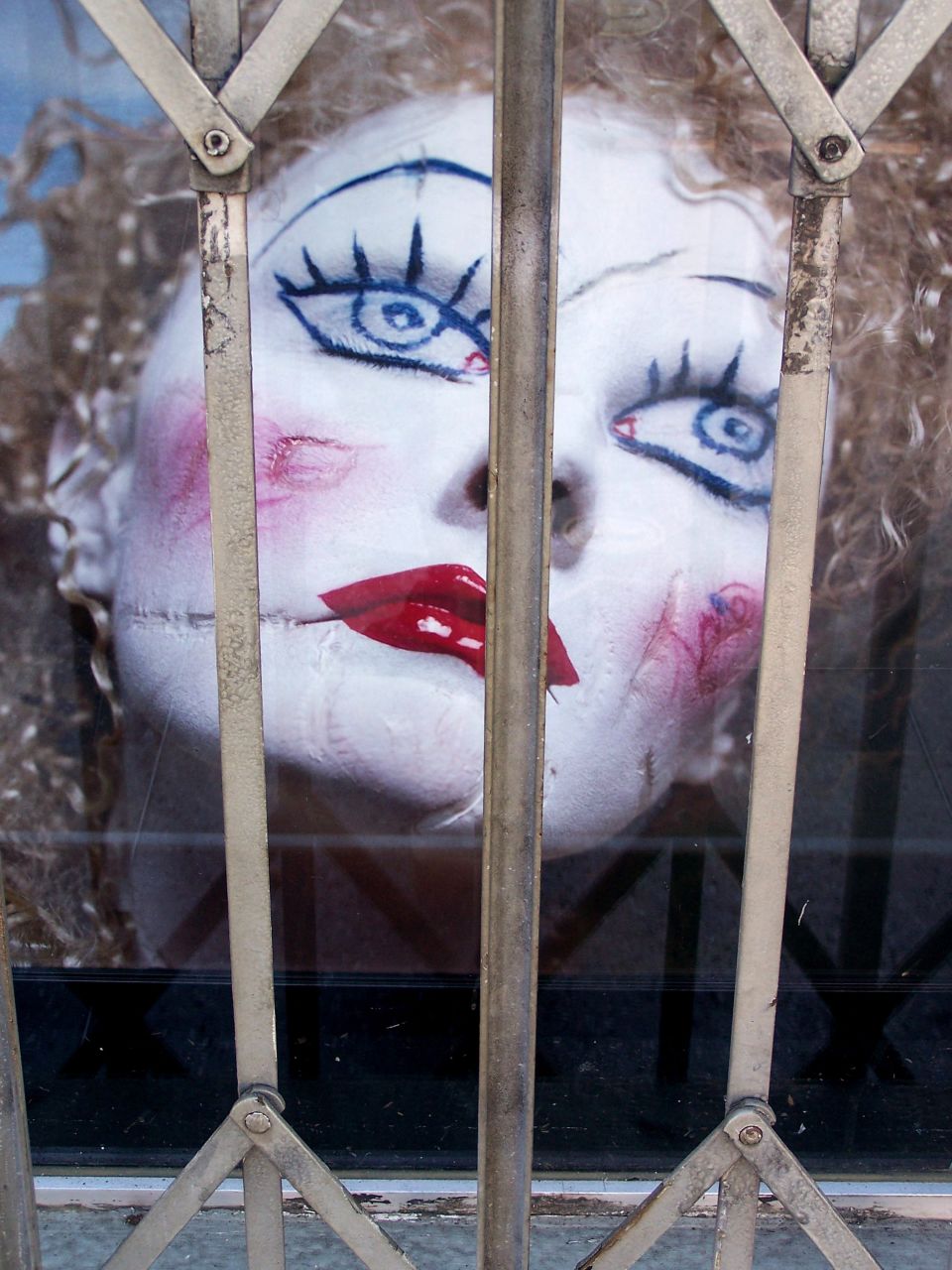 a doll is dressed as a creepy woman looking through the bars
