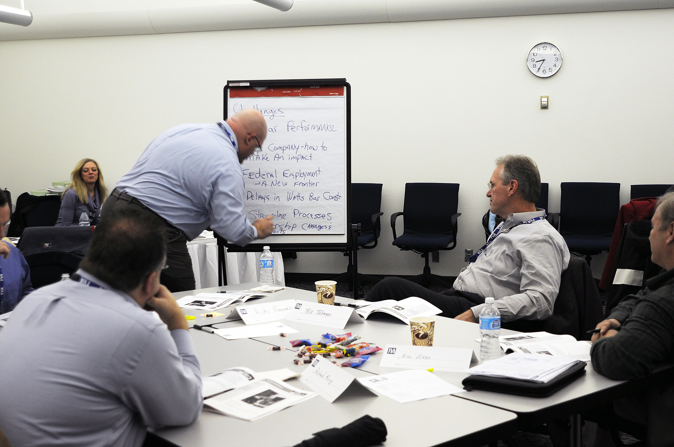 group of business people sitting around a table doing business notes