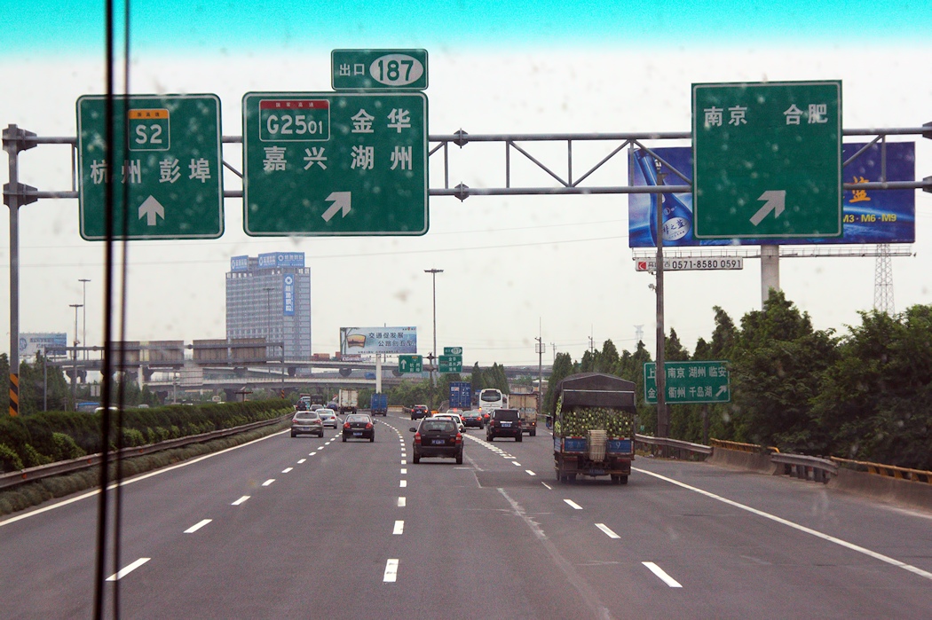 a street with multiple traffic signs hanging off of the side of it