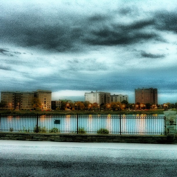 cloudy skies above some buildings and a lake