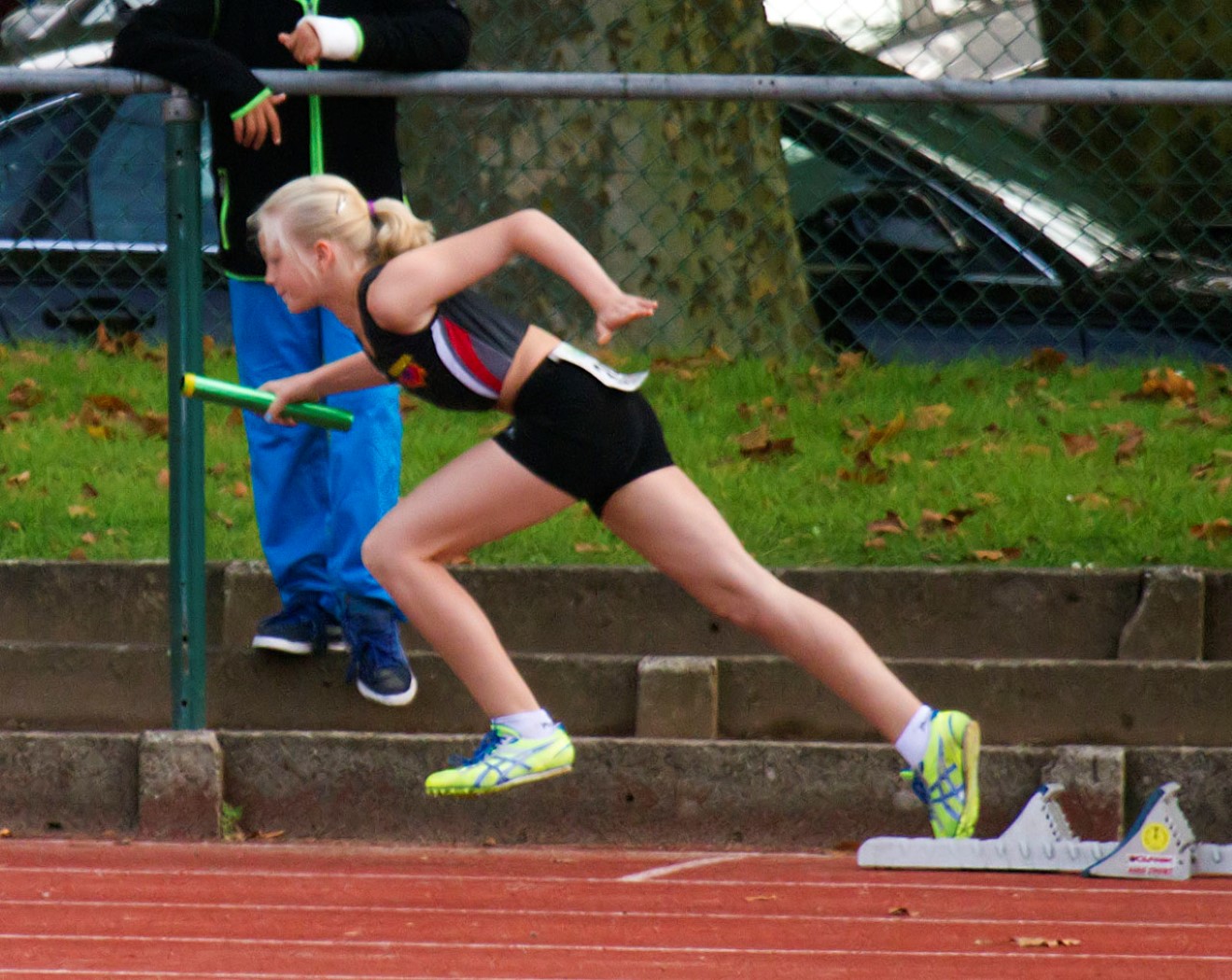 woman in running outfit in front of an obstacle course