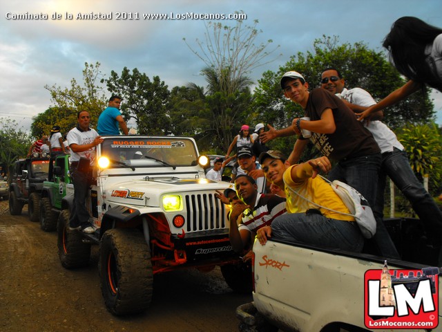 a group of people riding on top of a white jeep