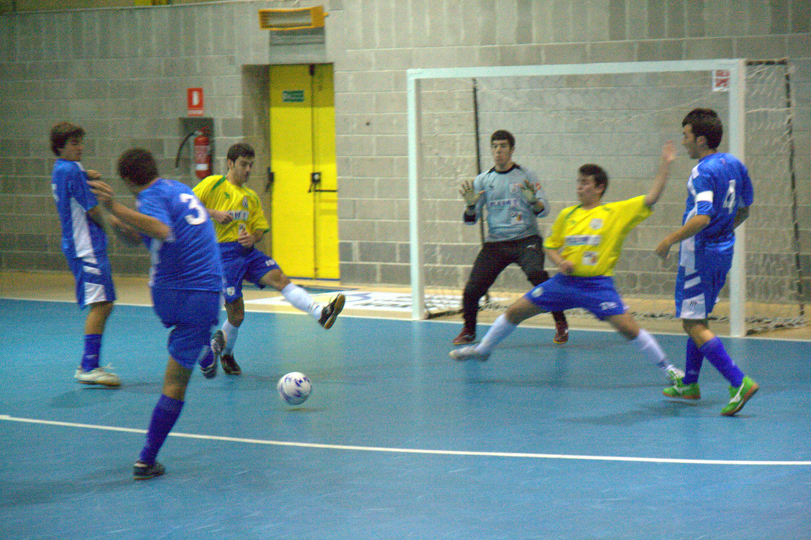 a group of men playing soccer in a gym