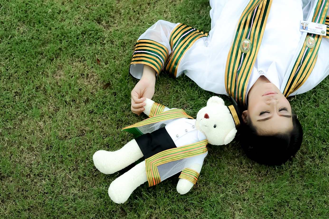 a woman laying on the ground next to a stuffed animal