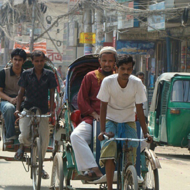 a group of boys riding bicycles in a busy street