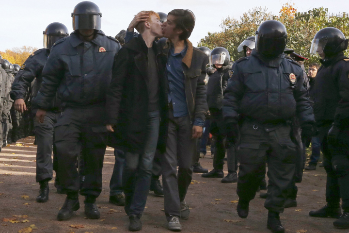 a couple kissing in front of a group of police