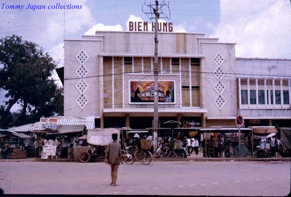 a man is walking down the street towards a shop