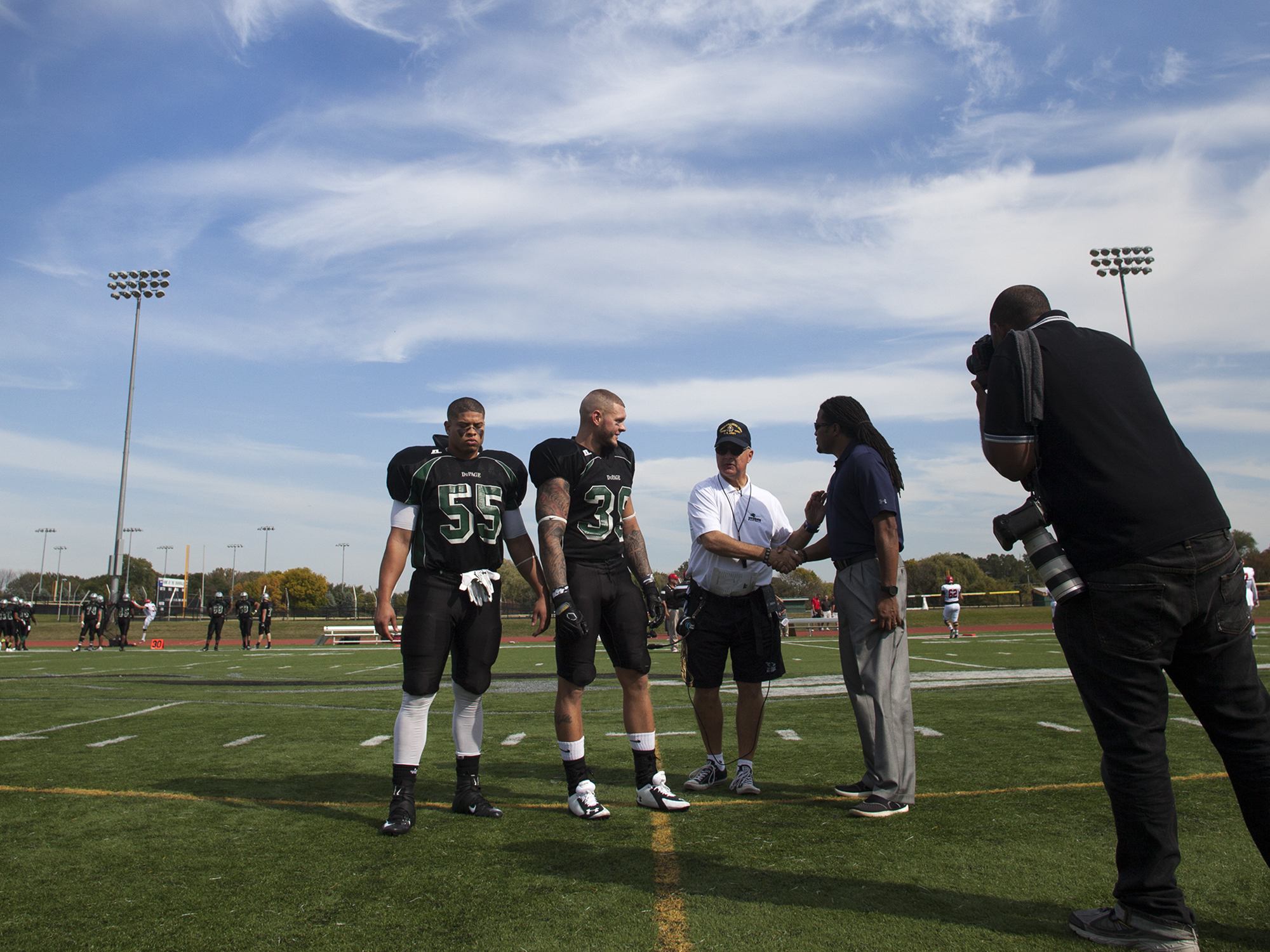 several players standing around on the field on a cloudy day