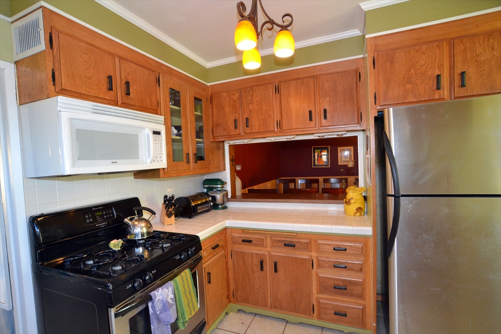 a kitchen with refrigerator, stove and microwave