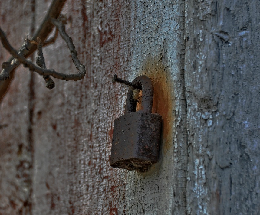 an old padlock is attached to a wooden fence