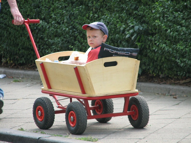 a boy in a wagon pulling a stroller