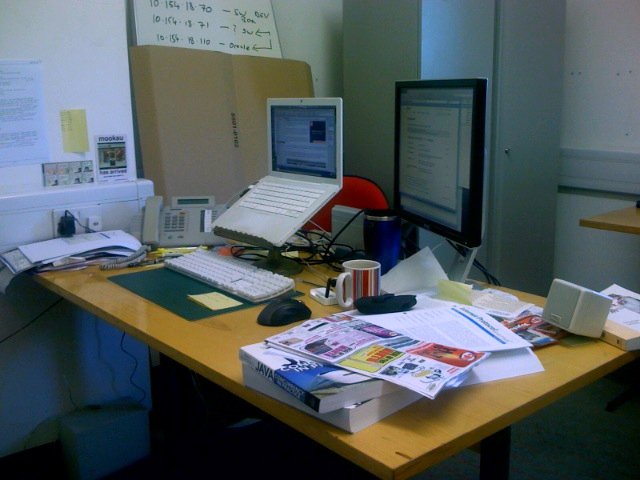 an office desk covered in clutter and paperwork
