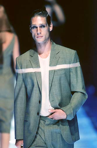 a man in a suit walking down a runway