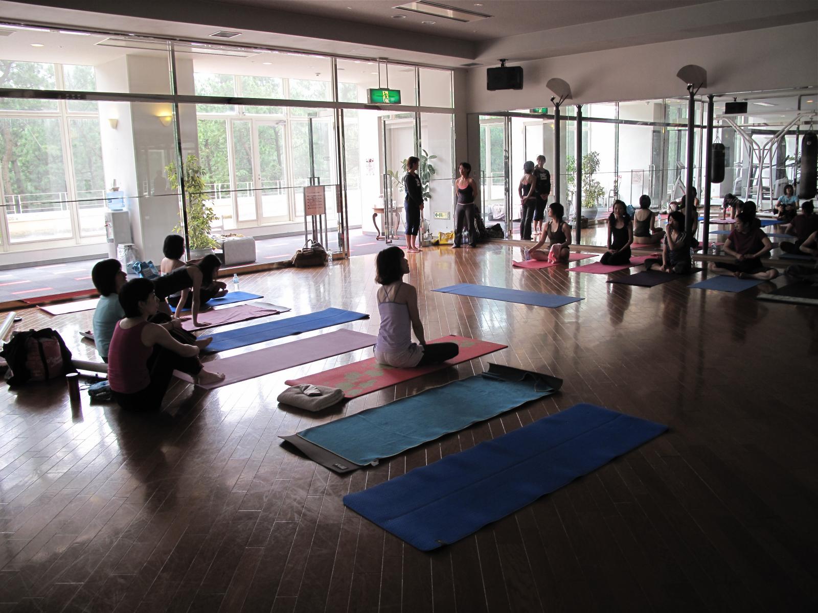 a large group of people doing yoga in a large room