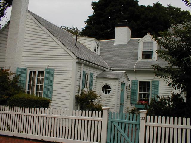 a white house with blue shutters and green shutters