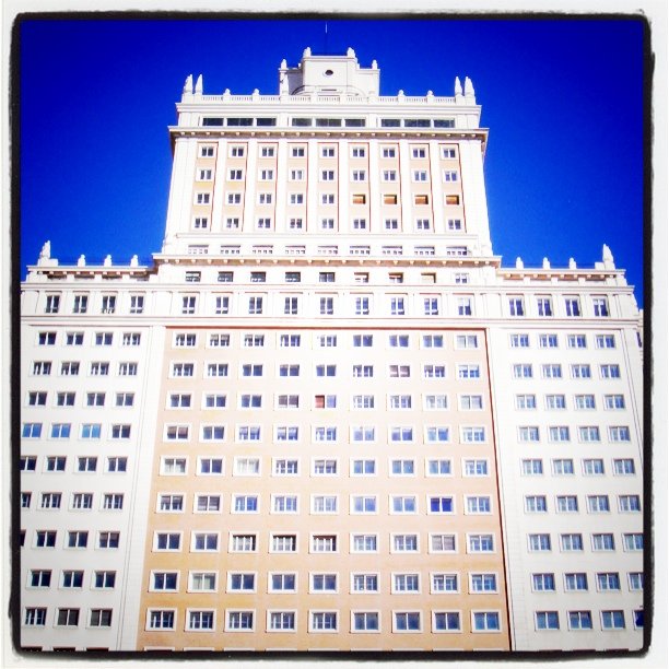 a tall building with white windows against a blue sky
