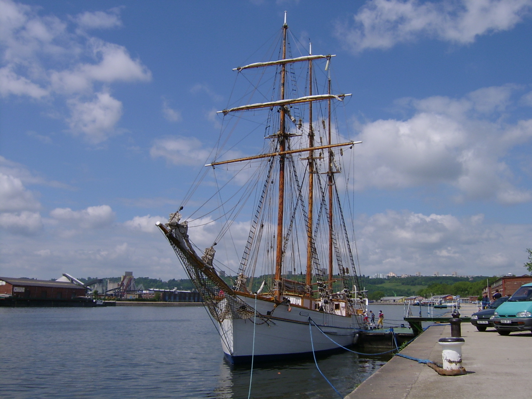 an old sailing boat sits at the dock