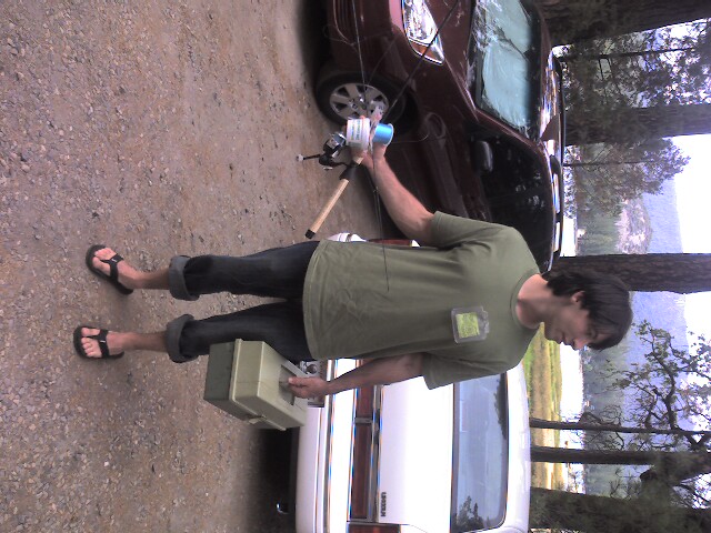 a man standing next to a van, holding a bag and a toothbrush