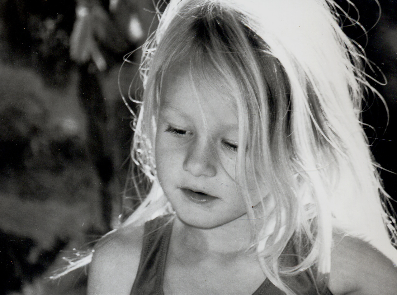 a black and white po of a child with long hair