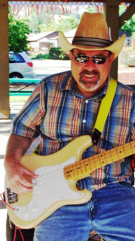 a man sitting on a bench holding an electric guitar