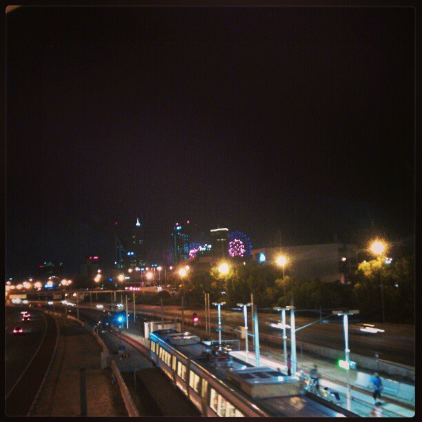 a city skyline at night with the train going down