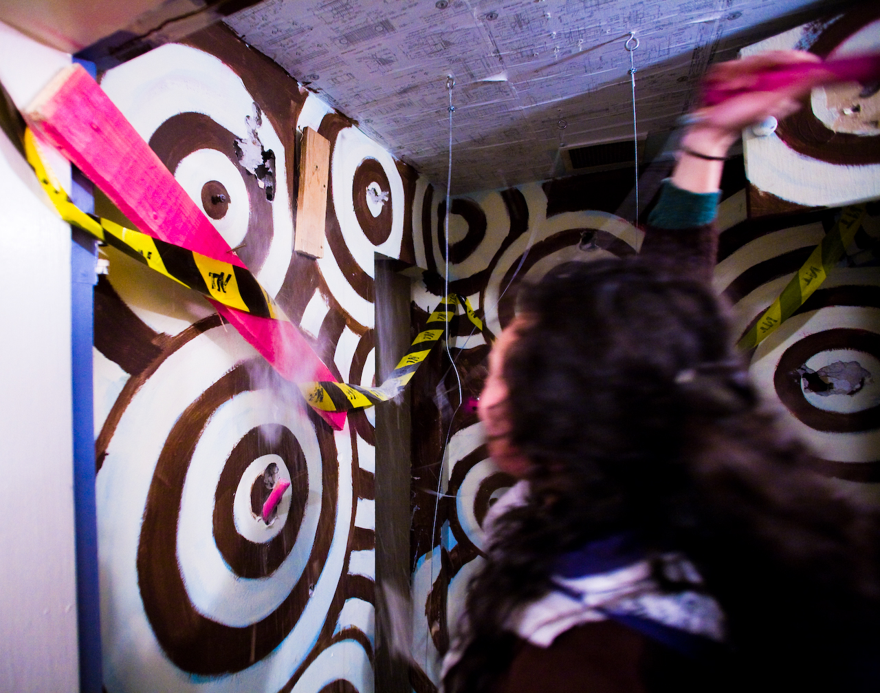 a woman stands in front of a mural that says and has ribbons flying from it