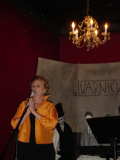 a woman with an orange jacket singing a song