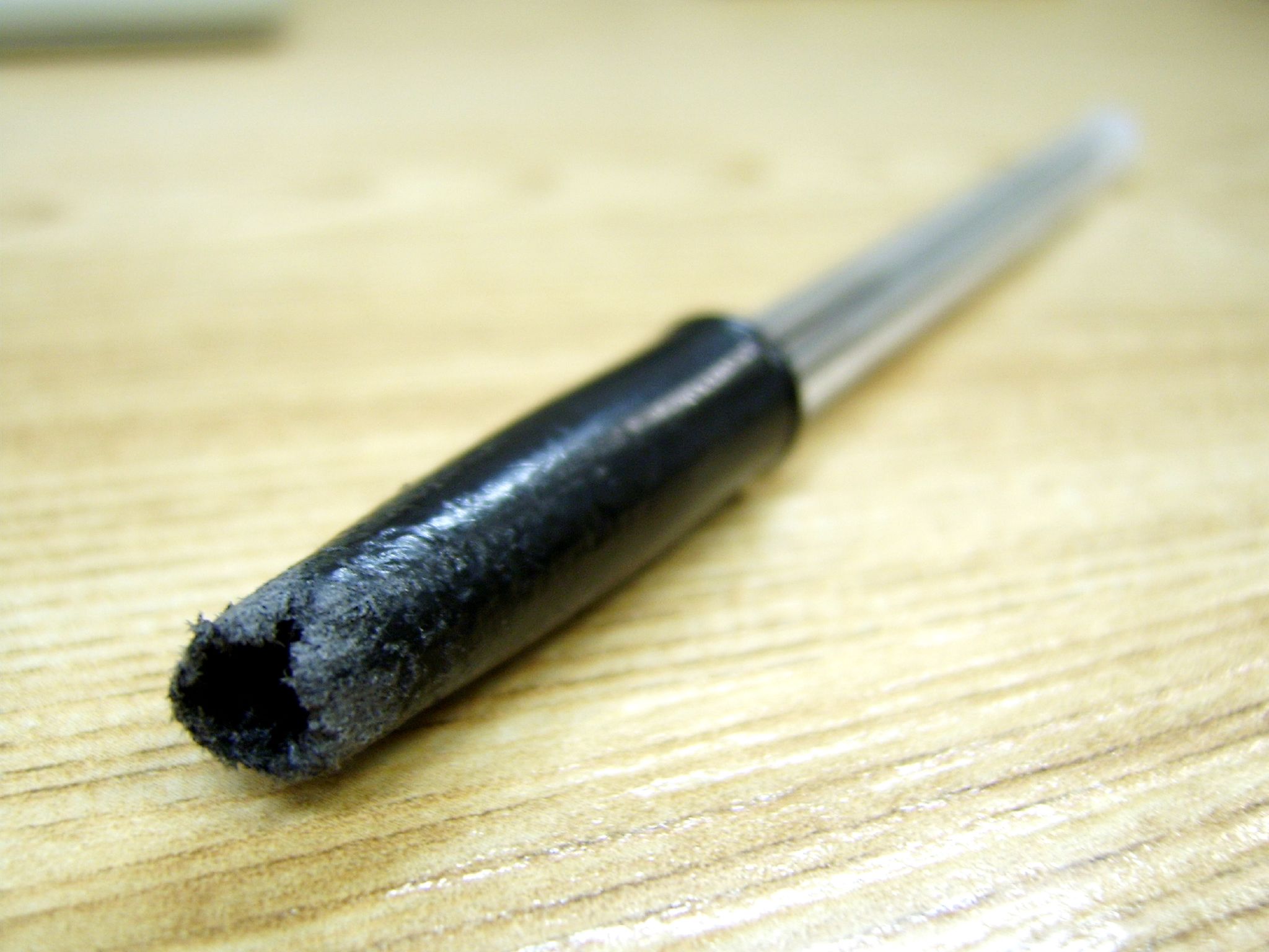 the metal tip of the wood is still covered with black residue