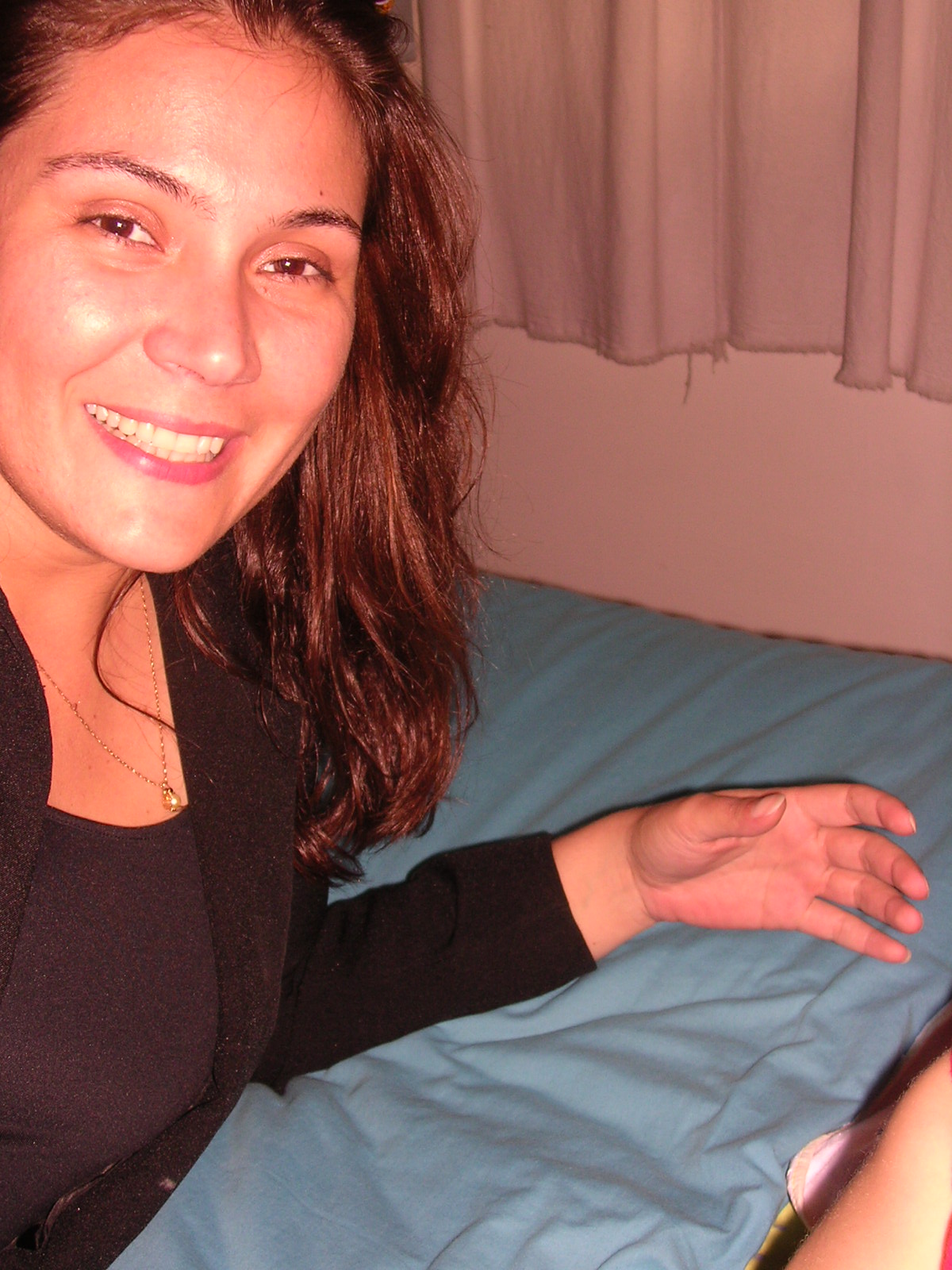 a woman sitting on the bed looking at the camera