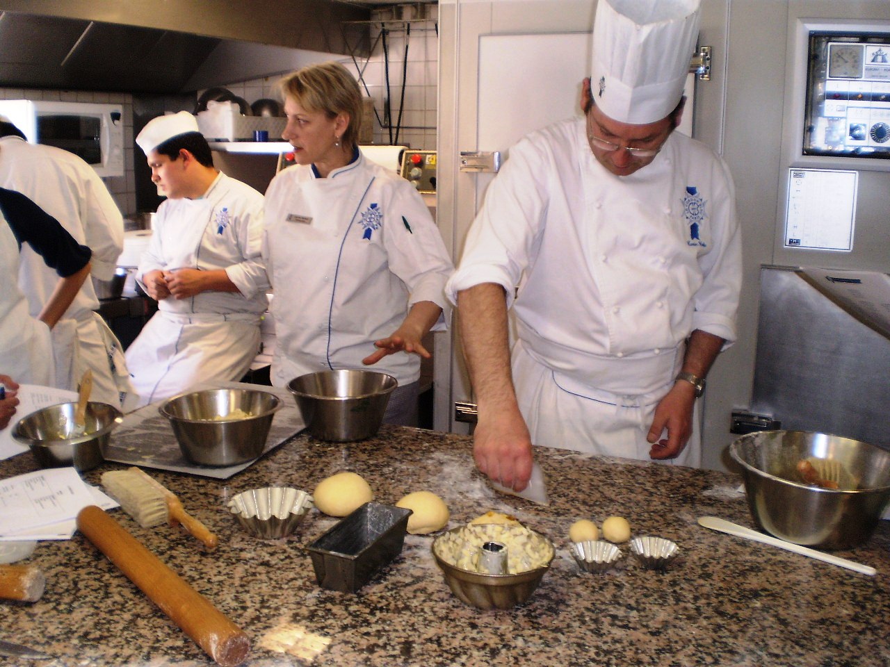 there are several chefs preparing food together in the kitchen