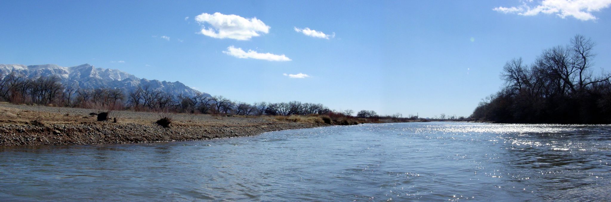 the man is standing by the river and fishing