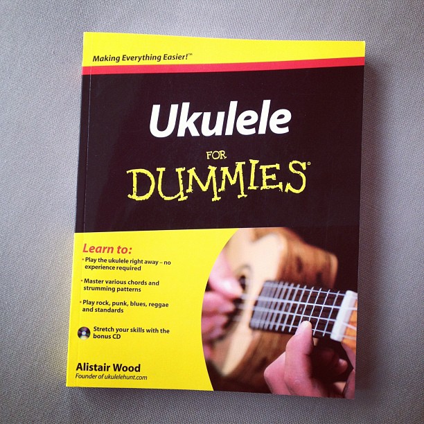 a book titled ukulele for dummies on a gray surface