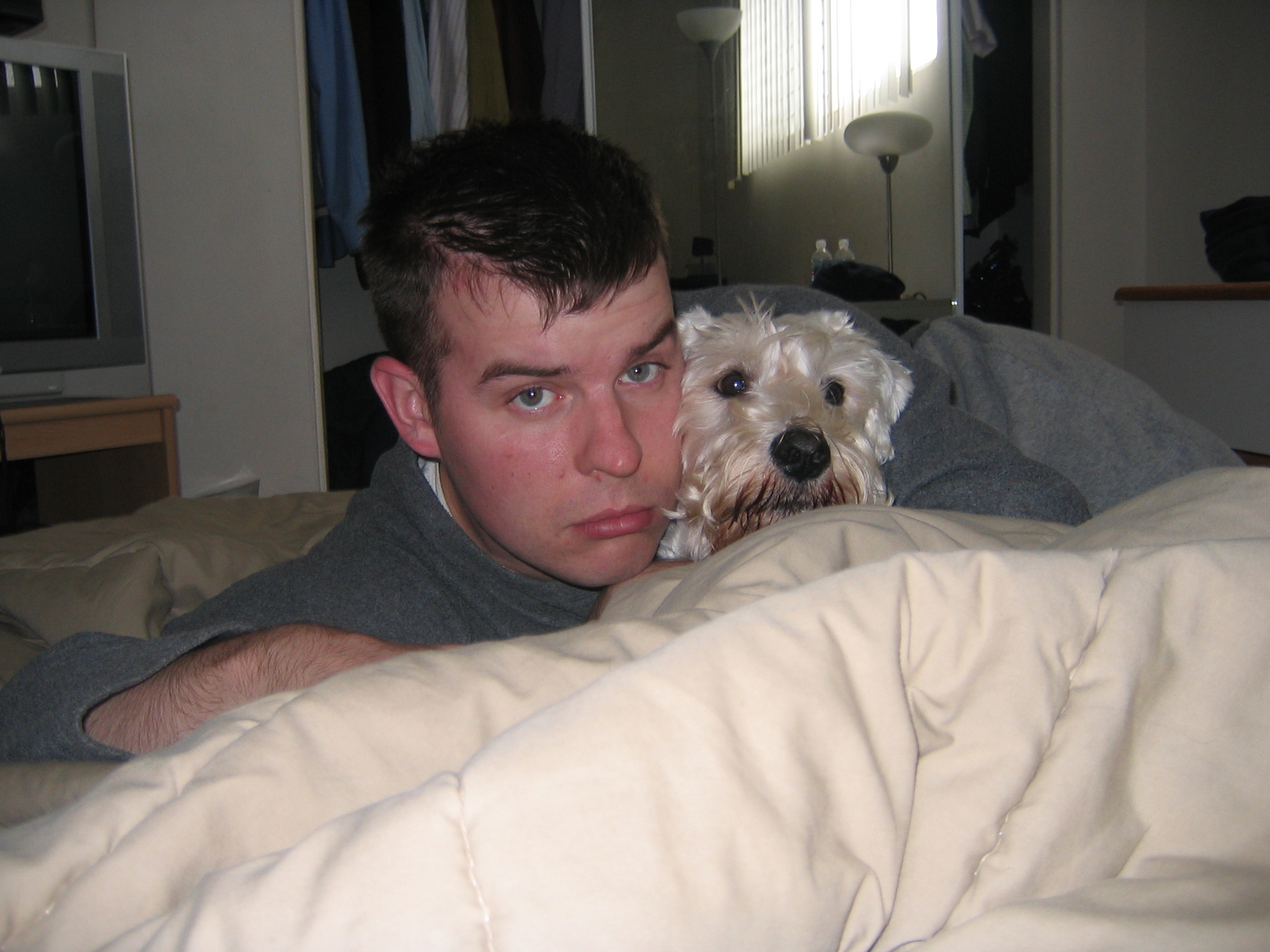 a man and dog resting in bed together